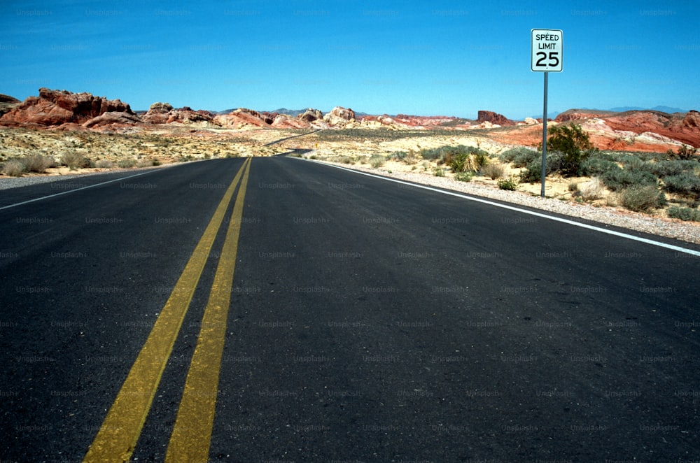 uma estrada com um sinal de limite de velocidade no meio