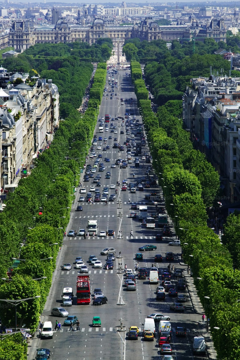 a city street filled with lots of traffic next to tall buildings