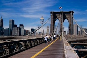 a group of people walking across a bridge