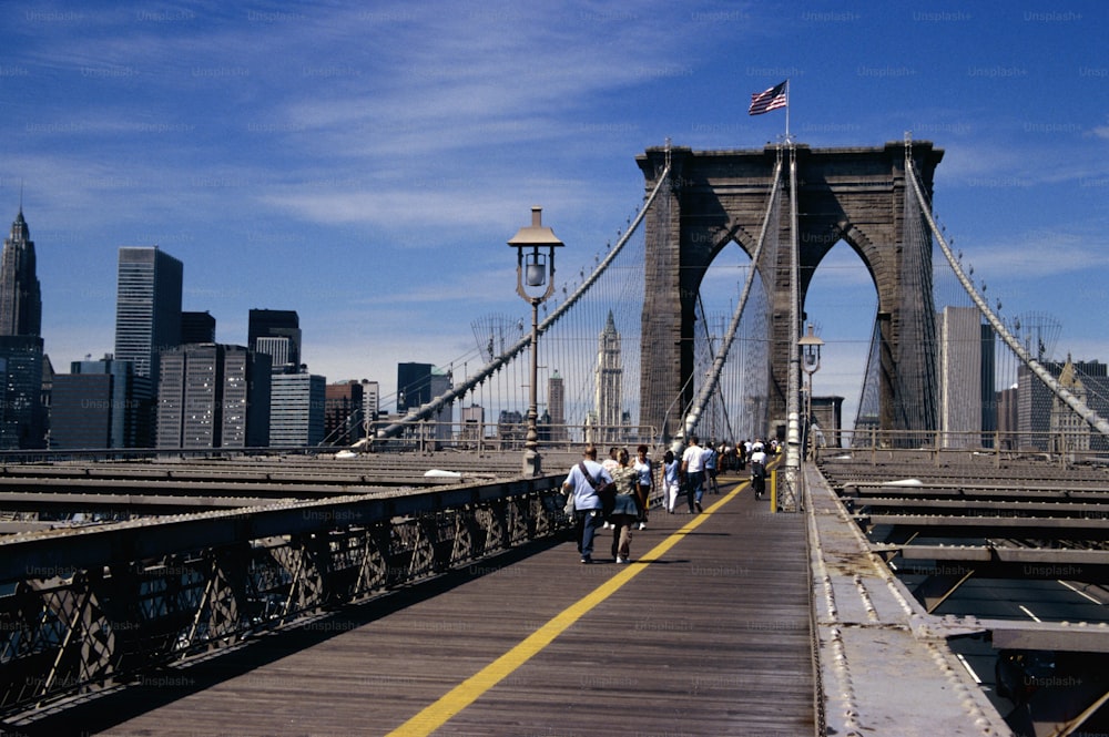 a group of people walking across a bridge