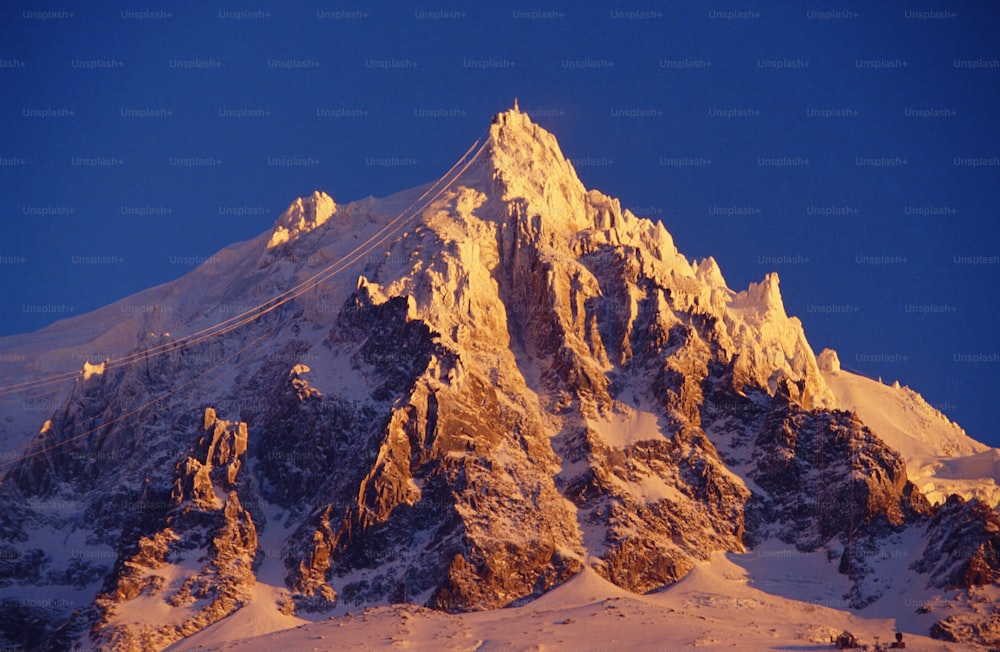 a mountain covered in snow under a blue sky