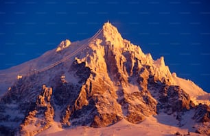 a mountain covered in snow under a blue sky