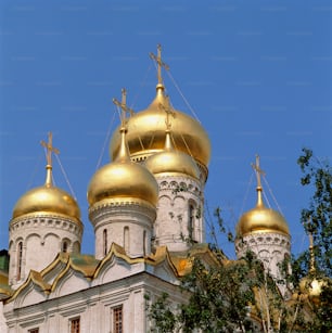 a large white and gold building with gold domes