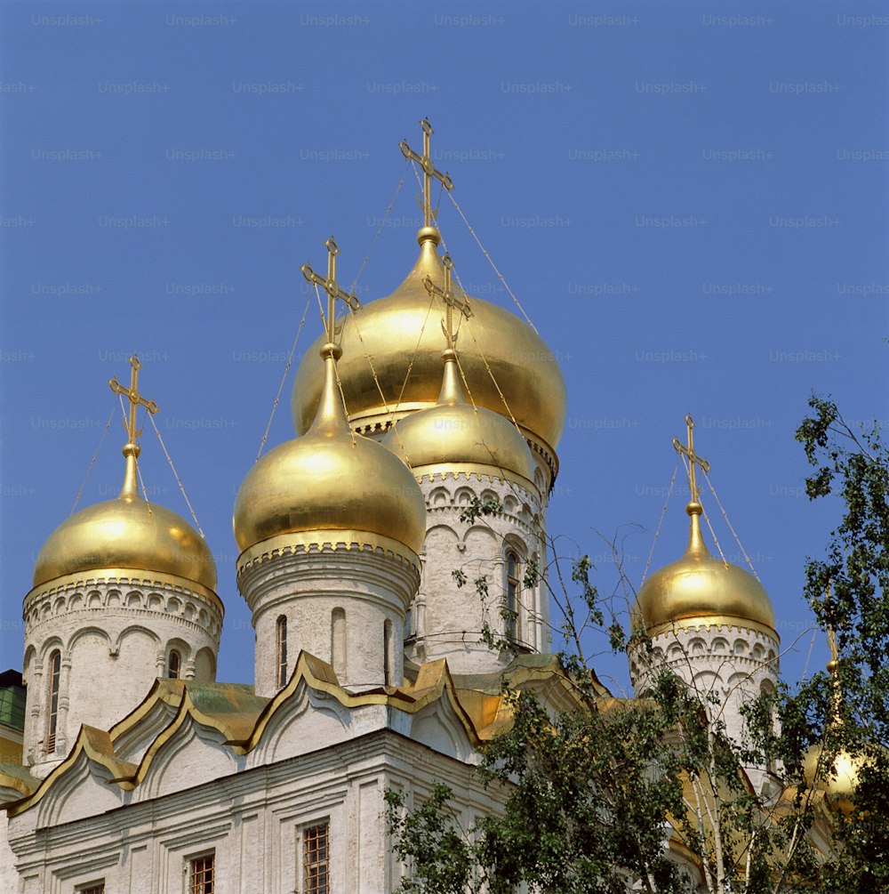 a large white and gold building with gold domes