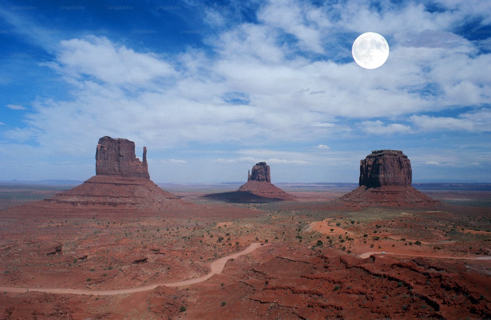 a full moon is seen over the desert landscape