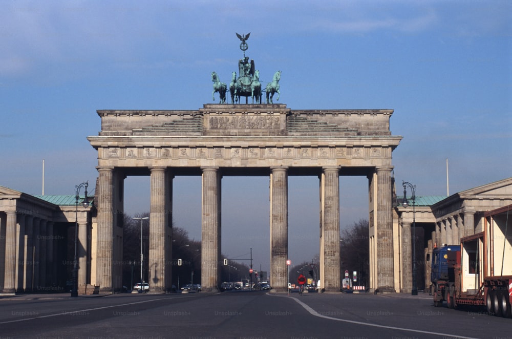 un grande arco di pietra con una statua in cima