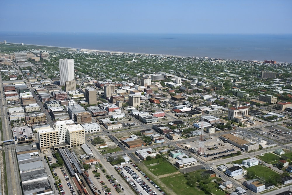 an aerial view of a city with a body of water in the background