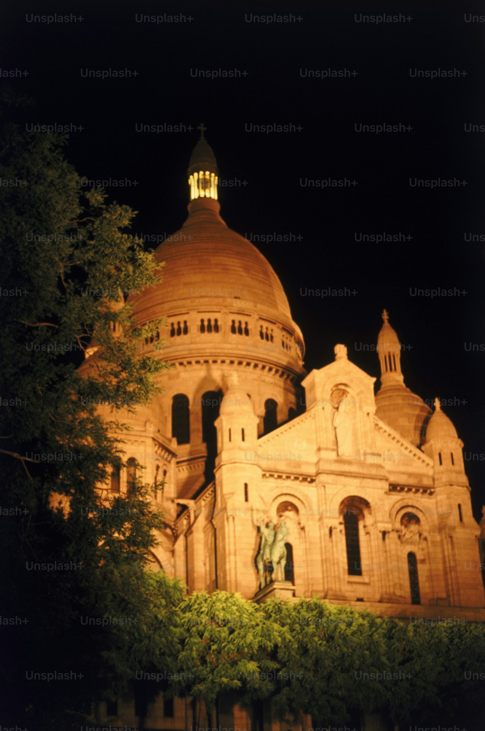 Un grande edificio con una torre dell'orologio di notte