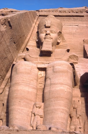 a large statue of an egyptian god in front of a building