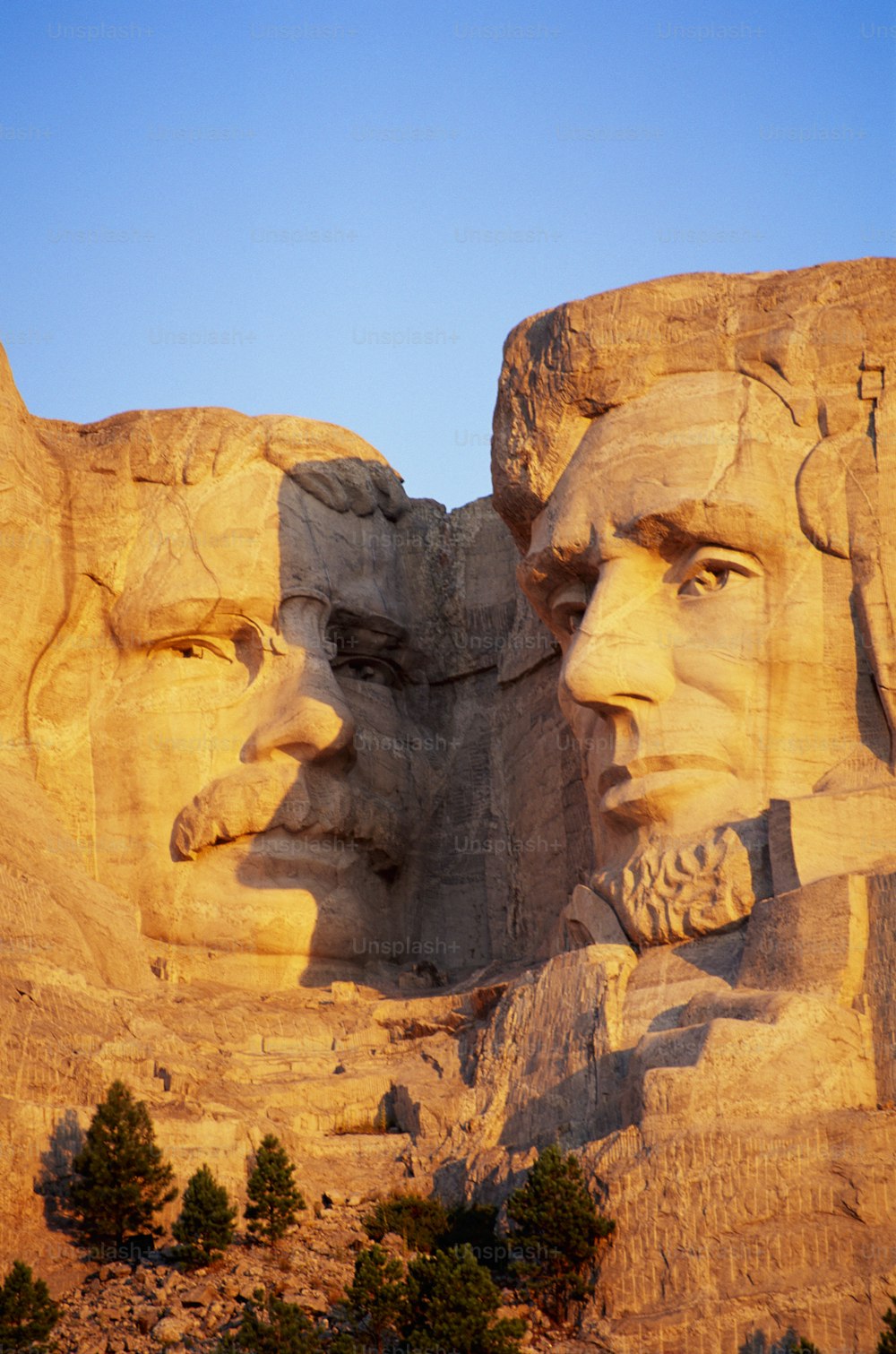 um close up dos rostos de presidentes esculpidos na encosta de uma montanha