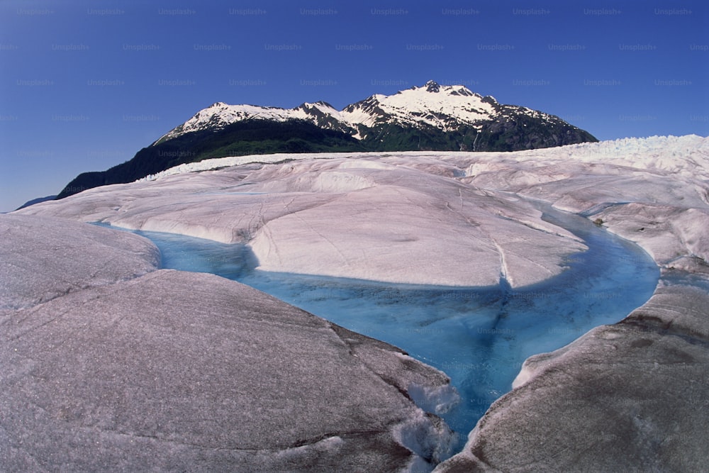 a river running through a glacier surrounded by mountains