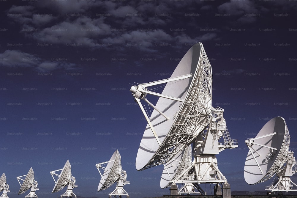a large array of satellite dishes sitting on top of a field