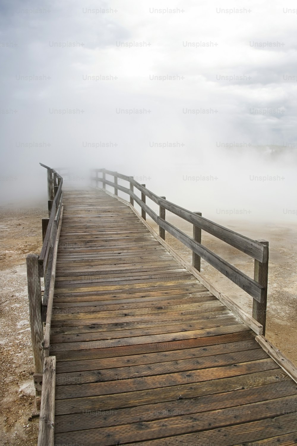 a wooden bridge with a foggy sky in the background