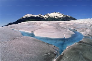 a river running through a glacier surrounded by mountains