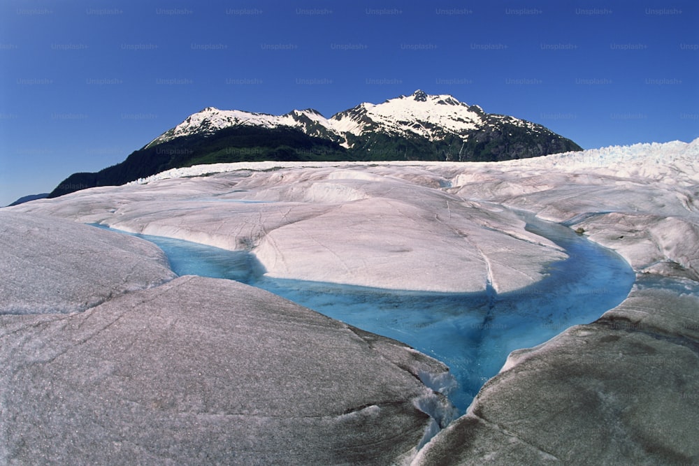 a river running through a glacier surrounded by mountains