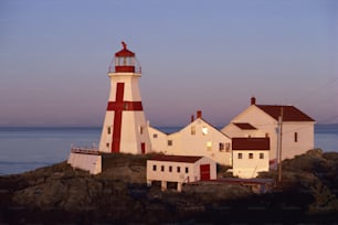 a red and white lighthouse sitting on top of a rock