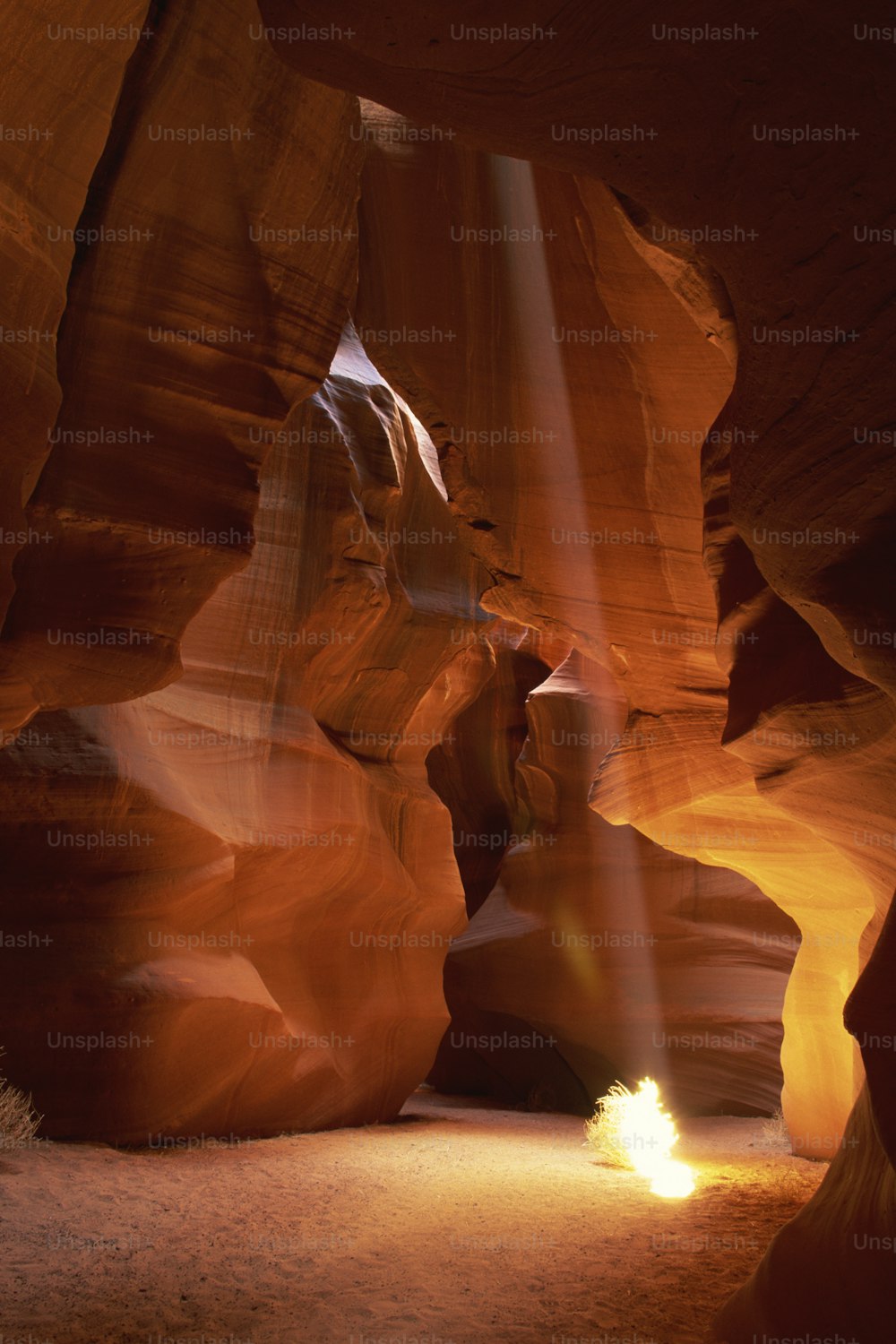 a light shines through a narrow slot in a canyon