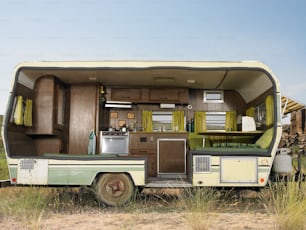 Um trailer antigo está estacionado em um campo