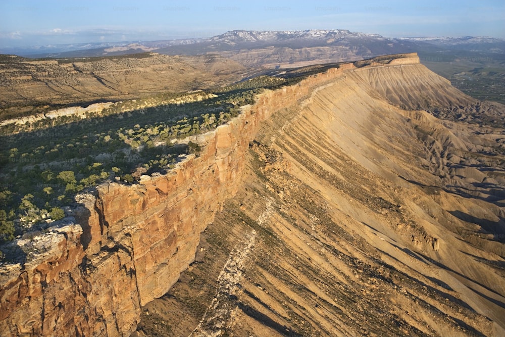 an aerial view of a canyon with a mountain in the background