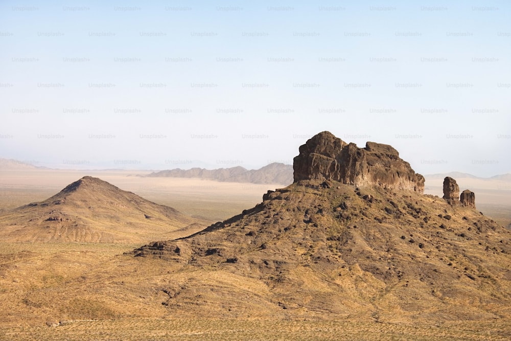 a herd of sheep standing on top of a dry grass covered hillside