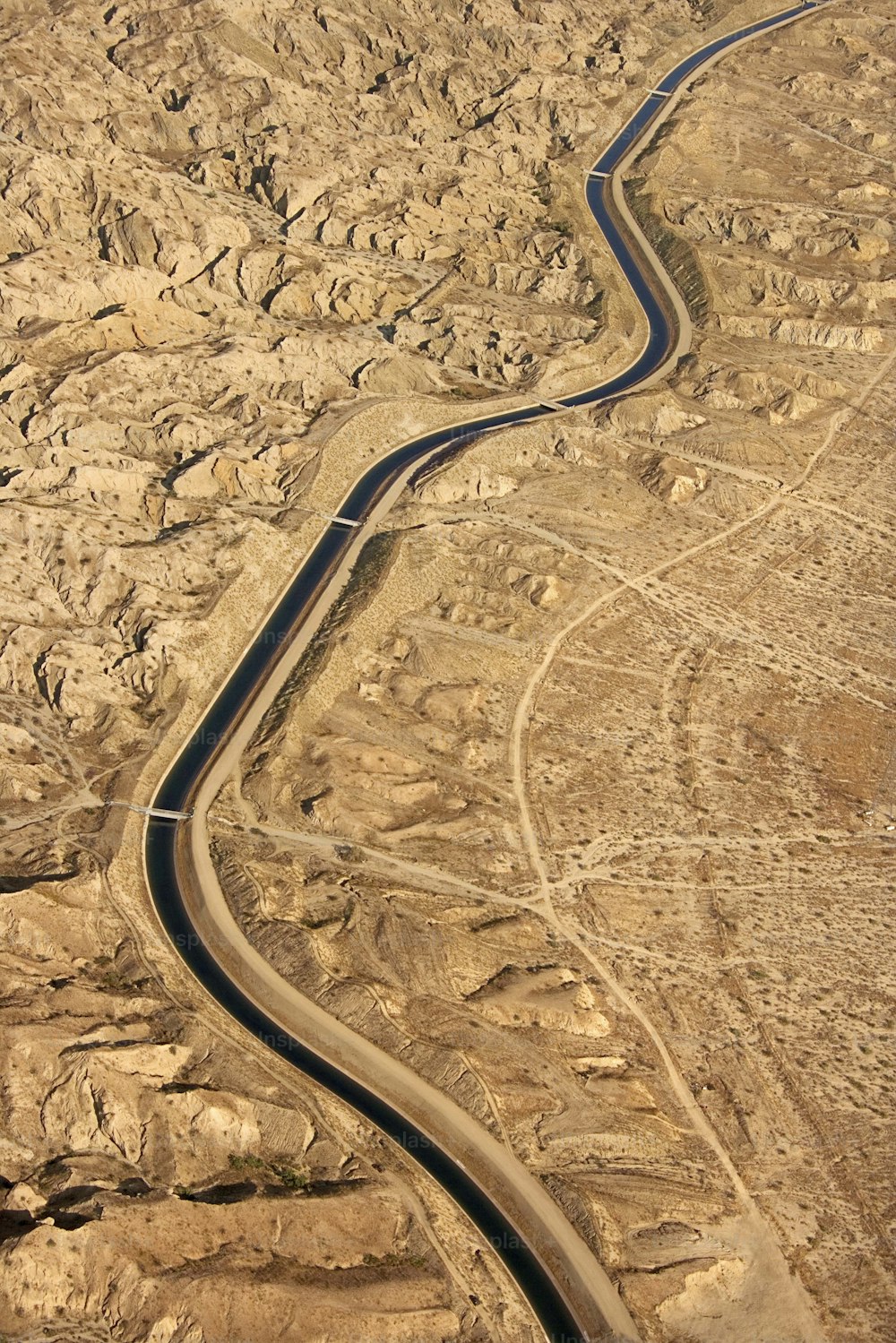 an aerial view of a winding road in the desert