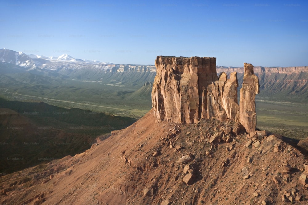 una grande formazione rocciosa seduta sulla cima di una montagna