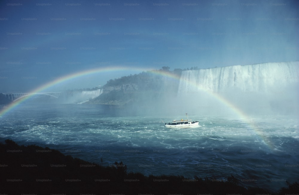 a boat in the water with a rainbow in the background