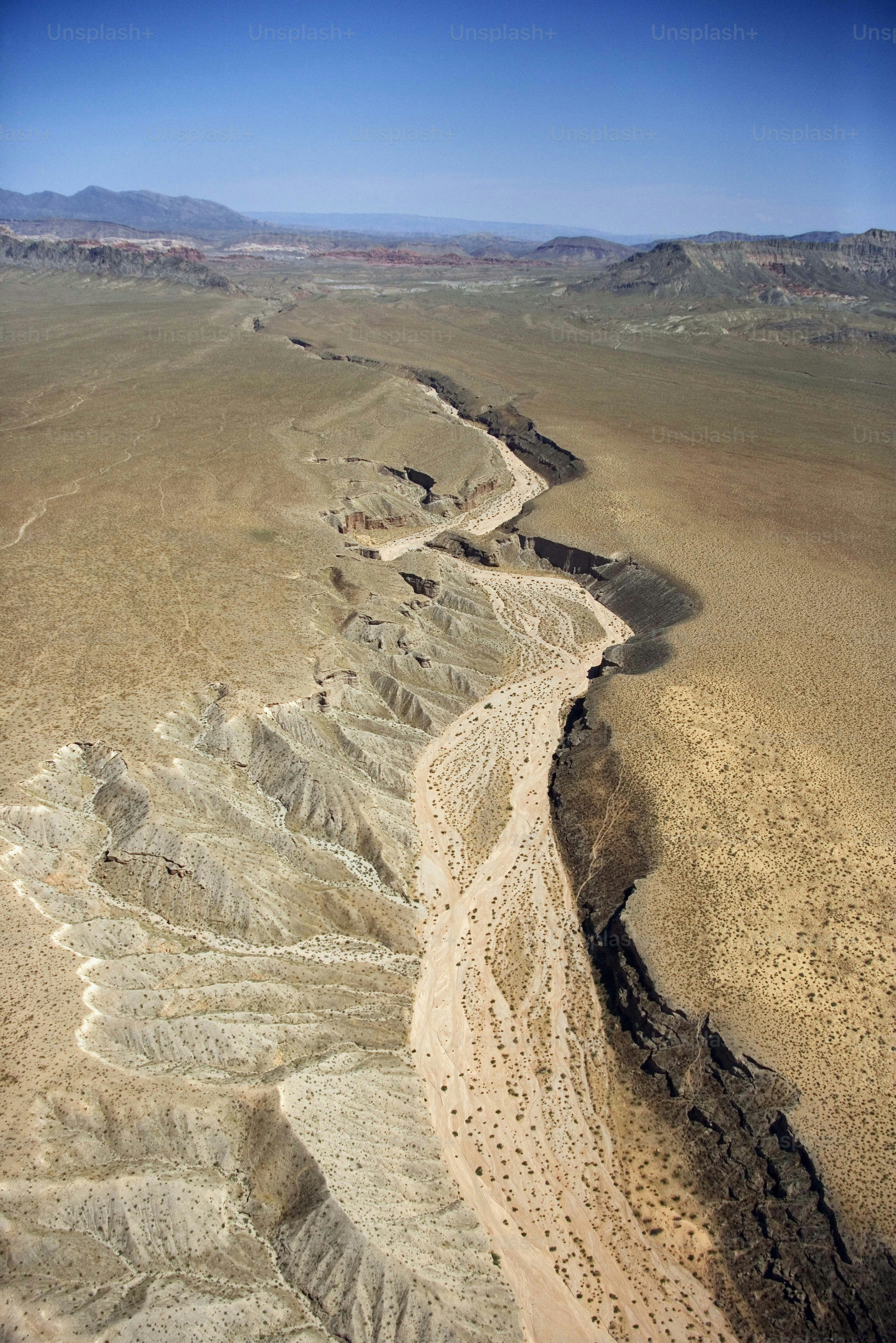 an aerial view of a desert with a river running through it