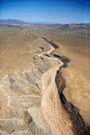 an aerial view of a desert with a river running through it