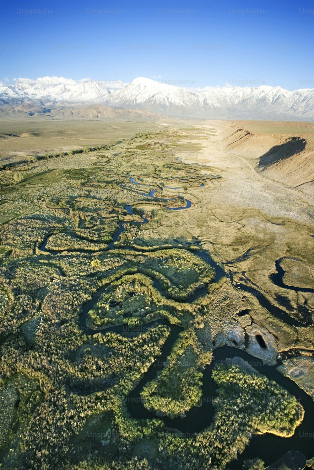 an aerial view of a landscape with mountains in the background