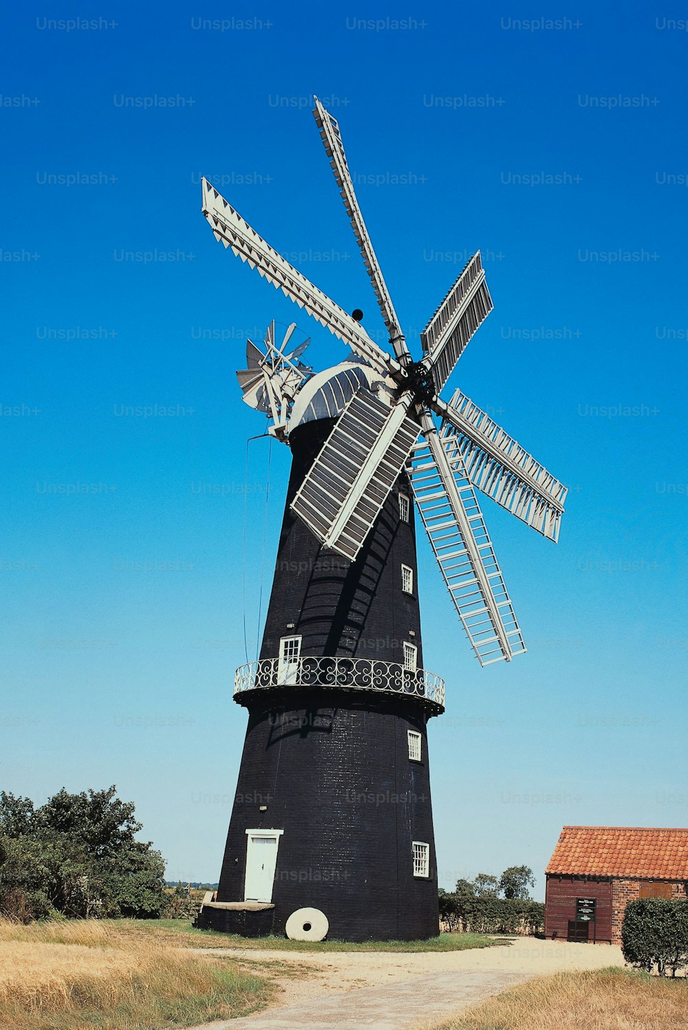 eine Windmühle auf einem Feld mit blauem Himmel im Hintergrund