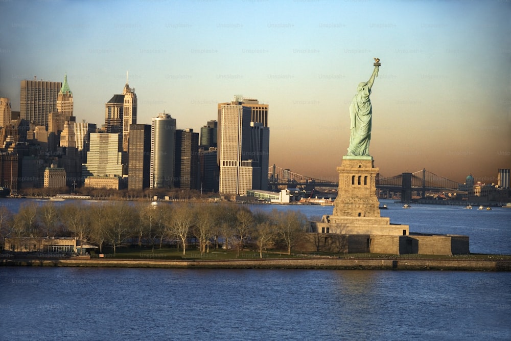 the statue of liberty stands in front of the city skyline