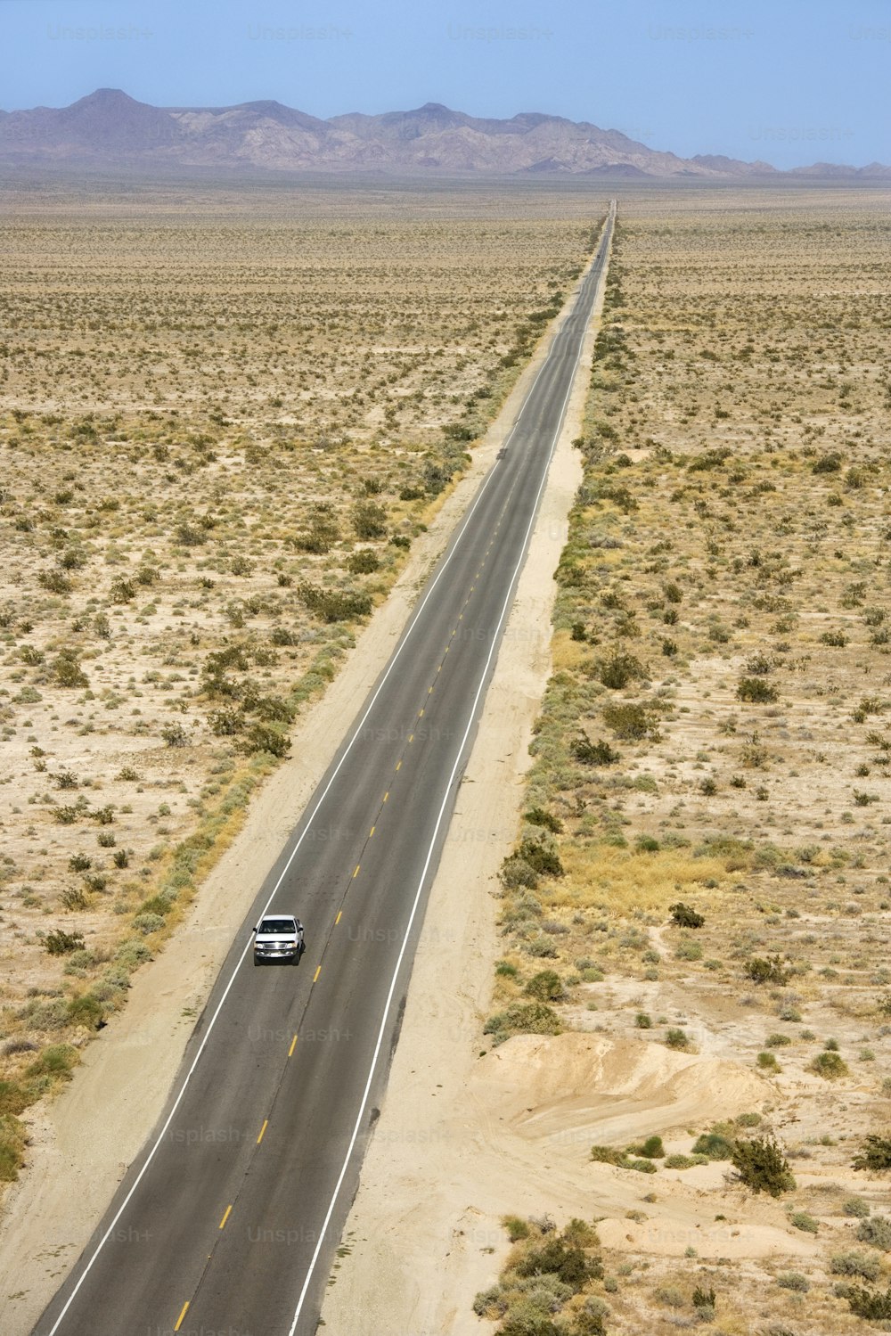砂漠の真ん中の道を走る車