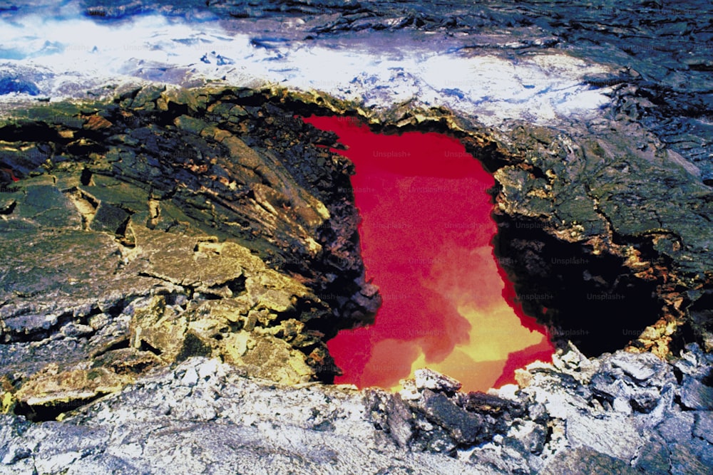 Um lago vermelho no meio de uma área rochosa