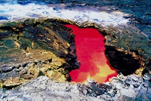 a red lake in the middle of a rocky area