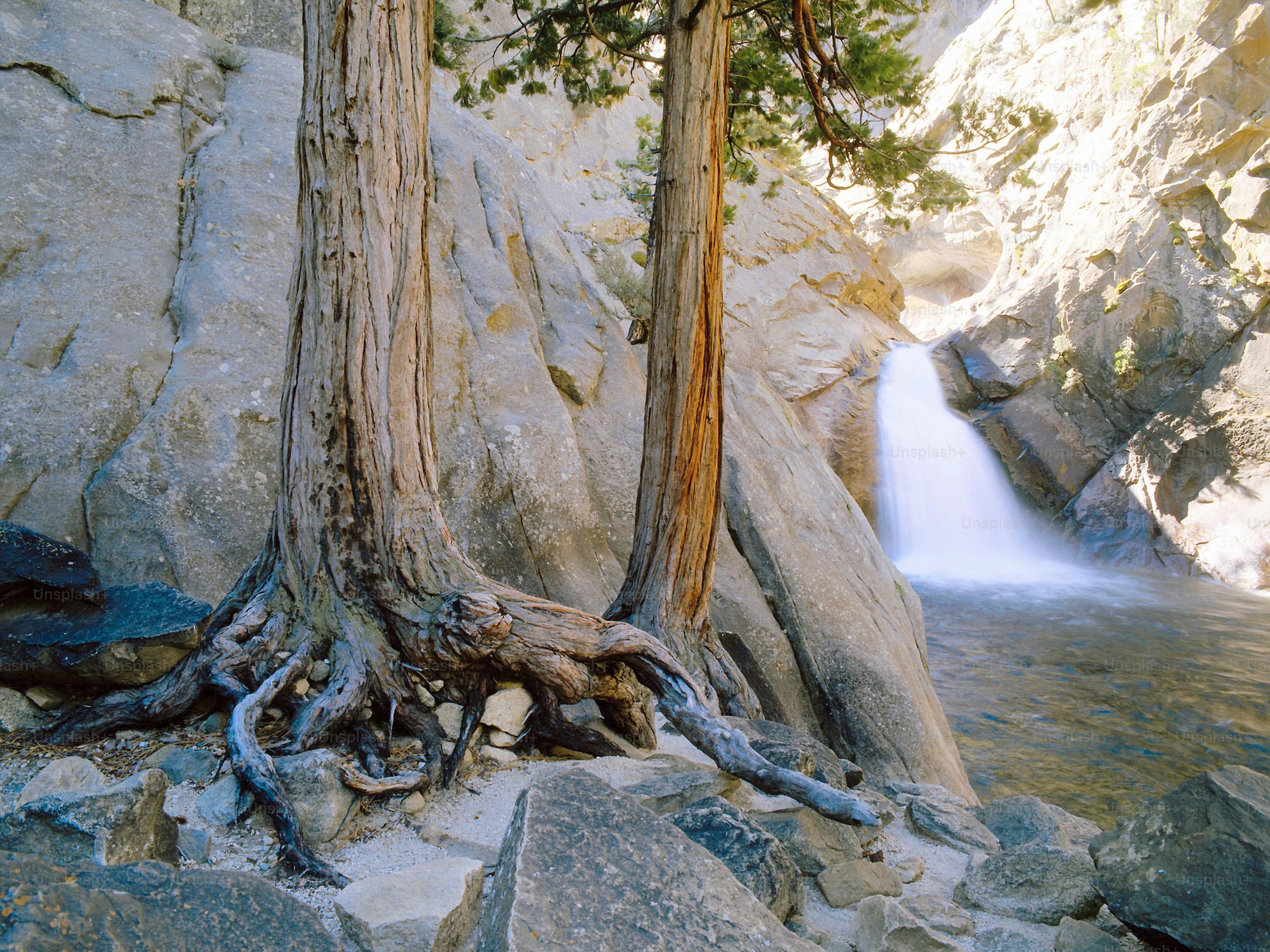 a waterfall is coming out of the rocks into the water