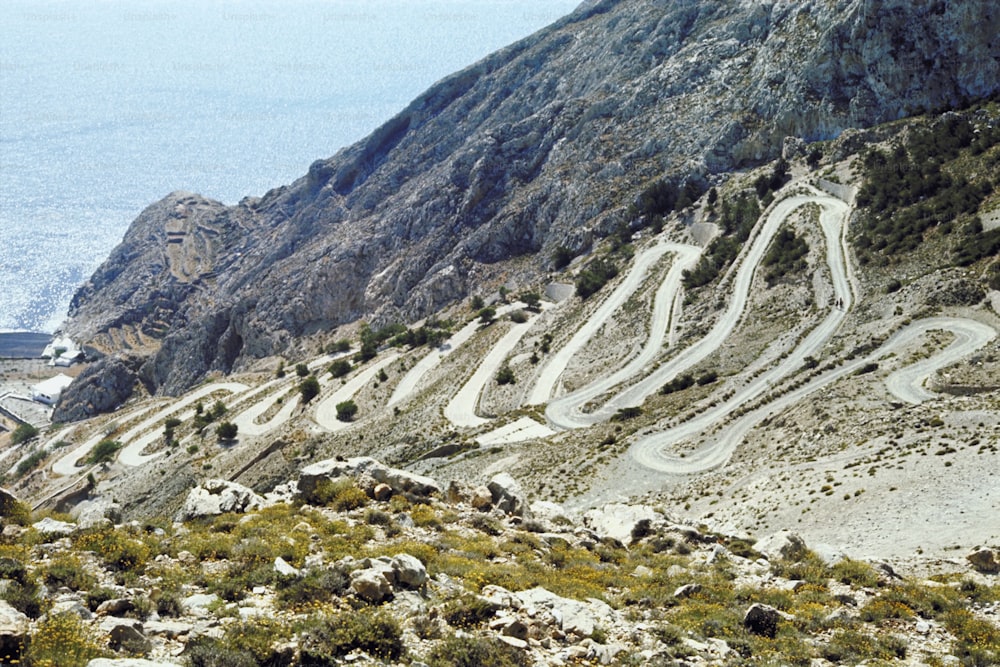 a winding mountain road with a view of the ocean