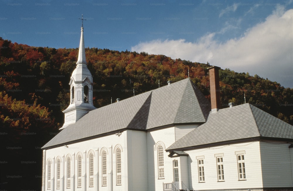 uma igreja branca com um campanário e um campanário no topo