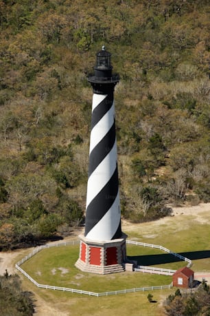 an aerial view of a lighthouse in the middle of a field