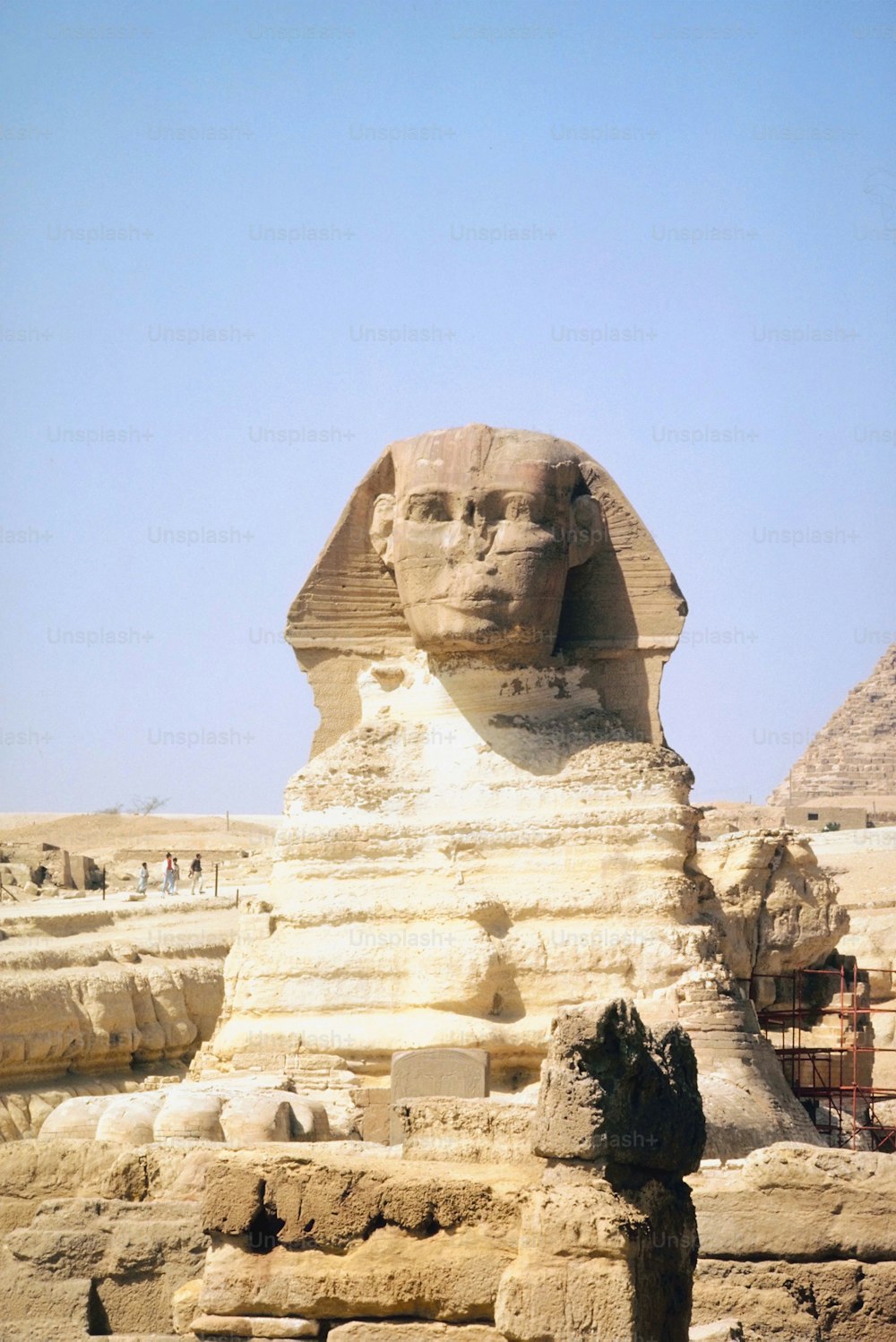 Una grande statua di sfinge di fronte a una piramide