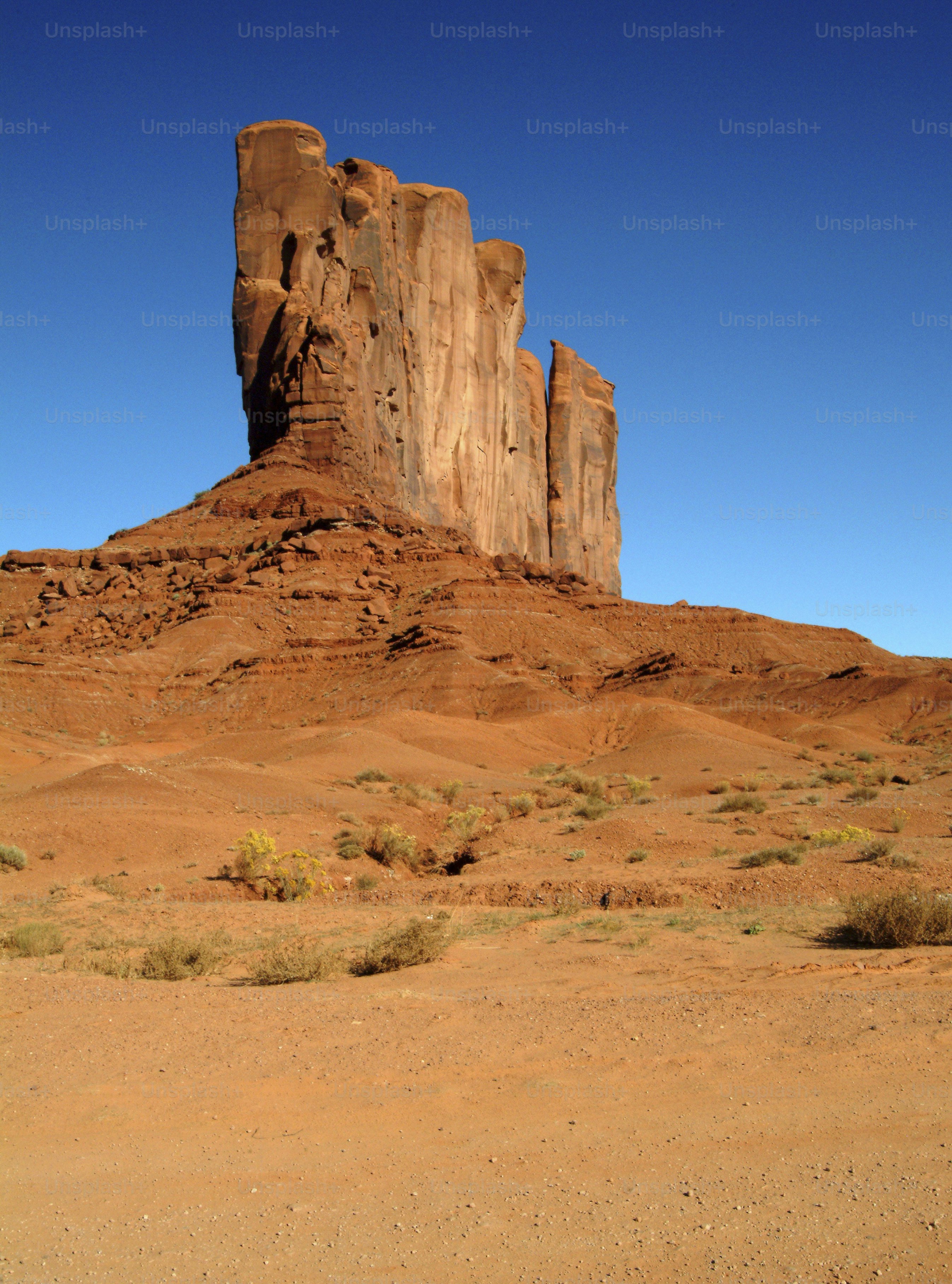 A large rock formation in the middle of a desert photo – Monument ...