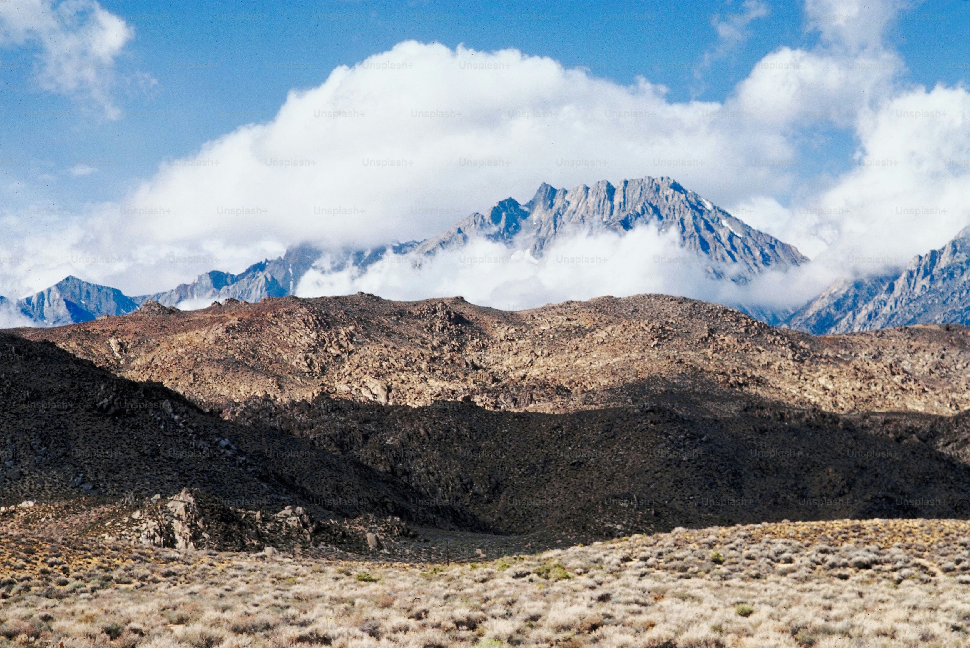 a view of a mountain range with clouds in the background