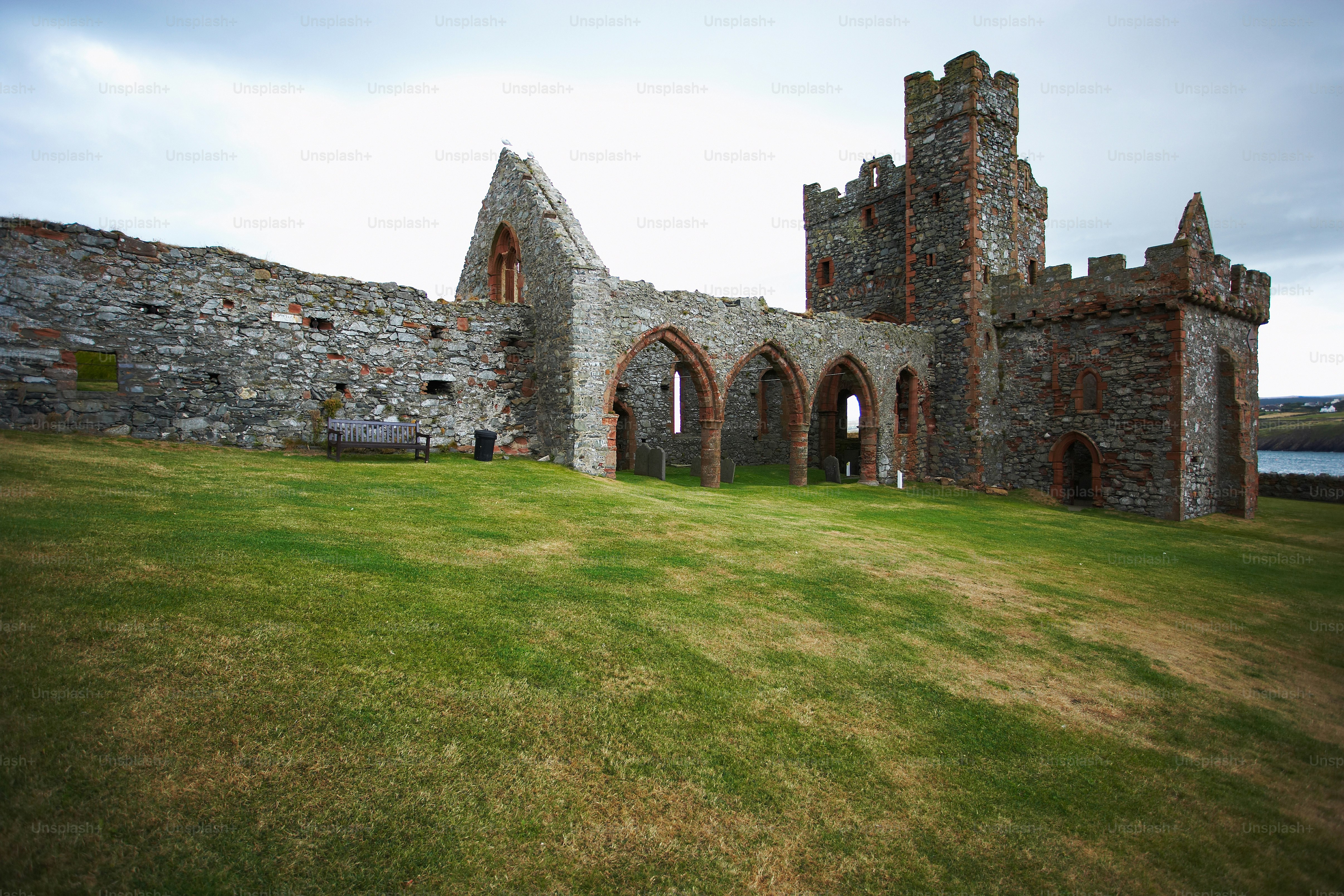 an old castle with a grassy field in front of it