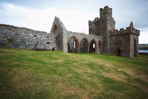 an old castle with a grassy field in front of it