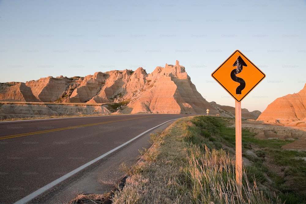 a yellow road sign sitting on the side of a road