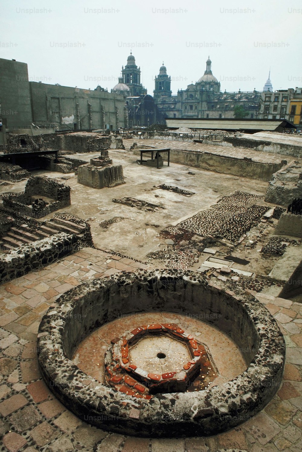a circular stone fire pit in the middle of a courtyard