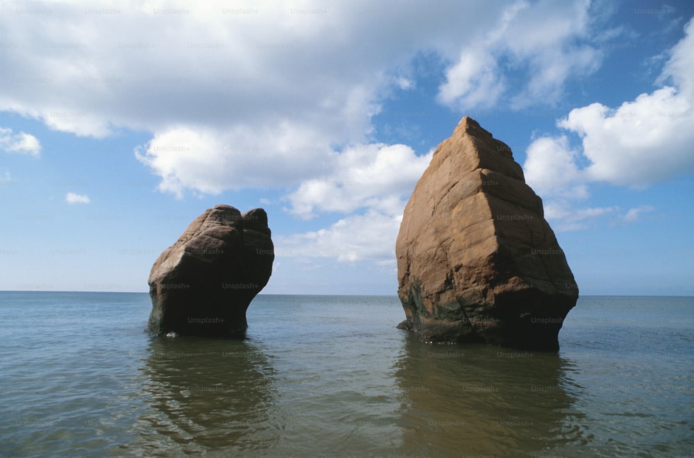 zwei große Felsen, die aus dem Wasser ragen