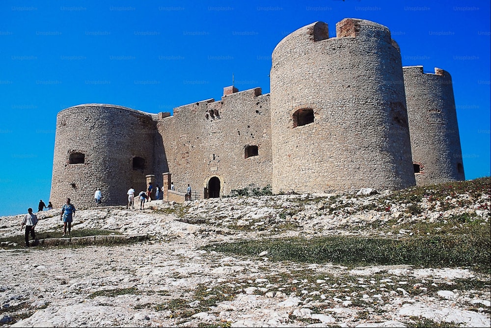 a group of people standing outside of a castle