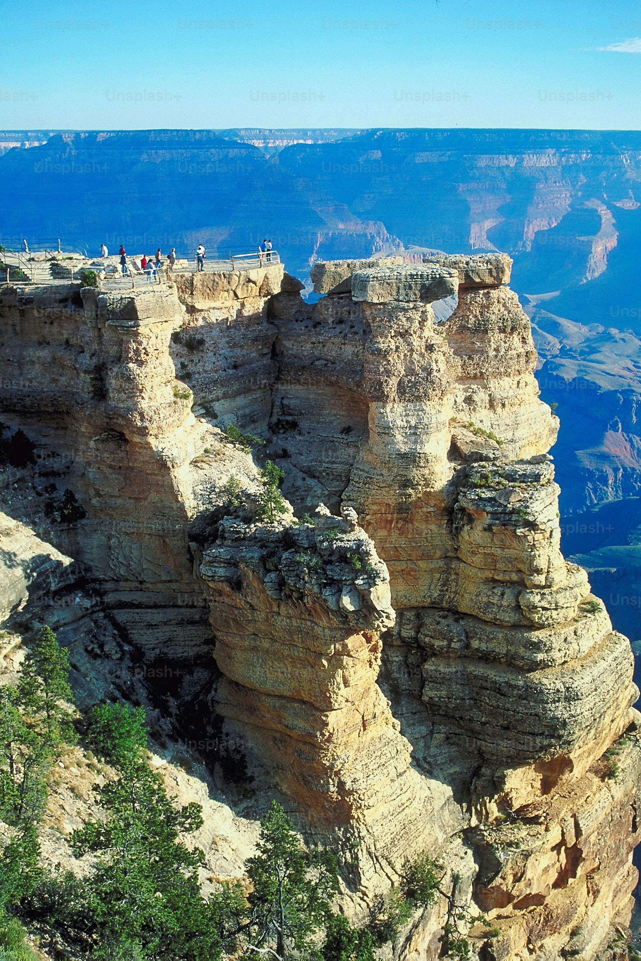 a group of people standing on the edge of a cliff