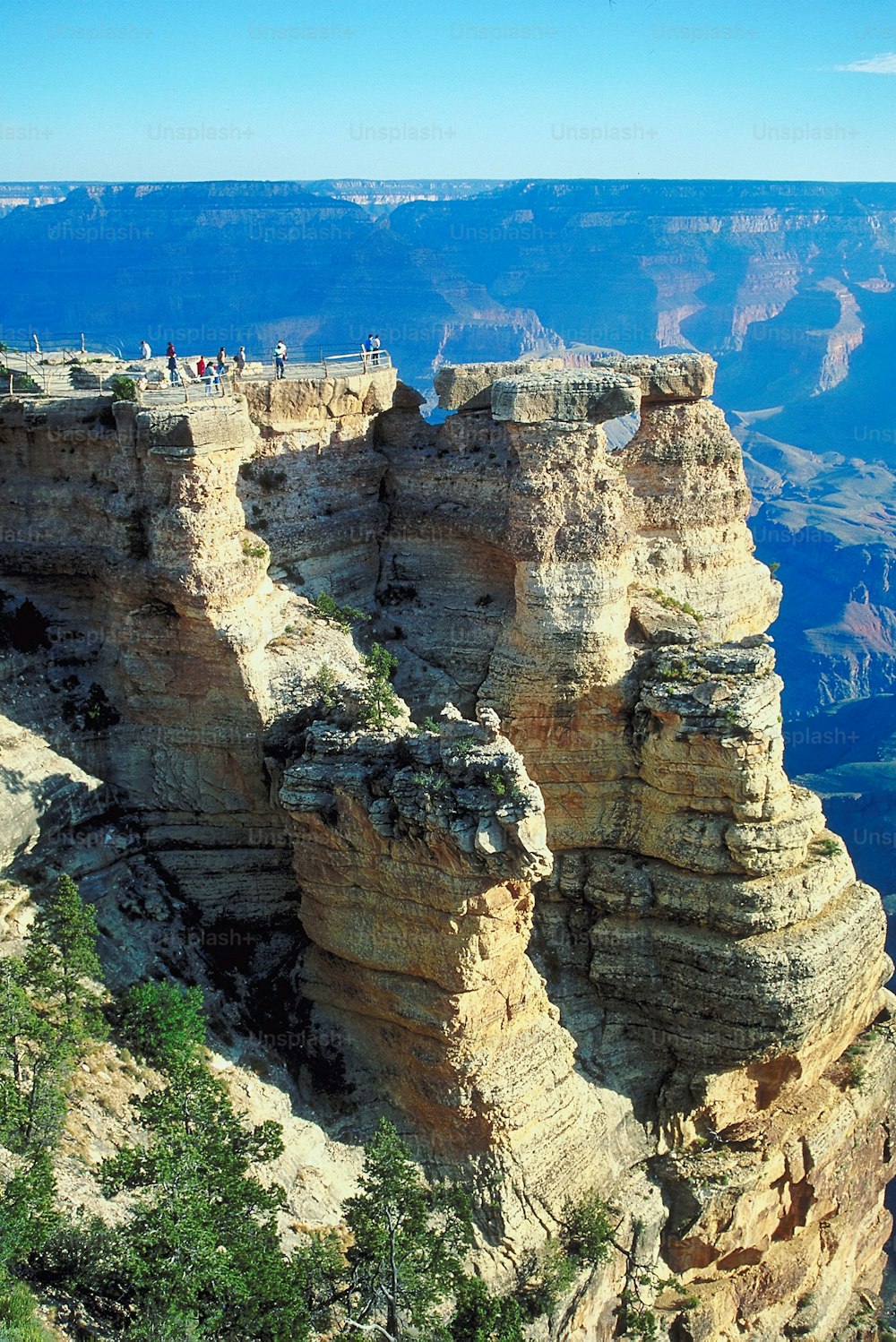 a group of people standing on the edge of a cliff